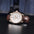 Sobrio dress watch, rose gold case and brown strap on a dark surface