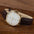 White-dial gold-tone small-seconds watch on wood
