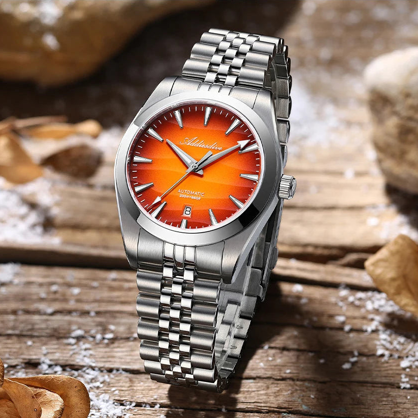 Reloj automático Duna con esfera naranja degradada fotografiado sobre madera natural